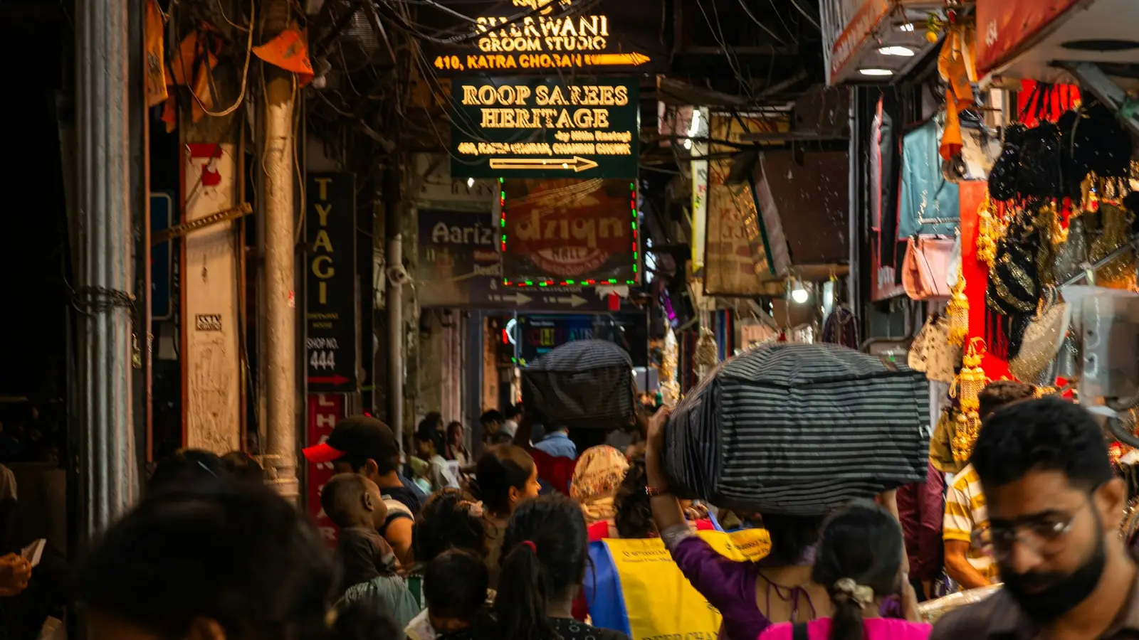 A crowded Indian market street lit up at night