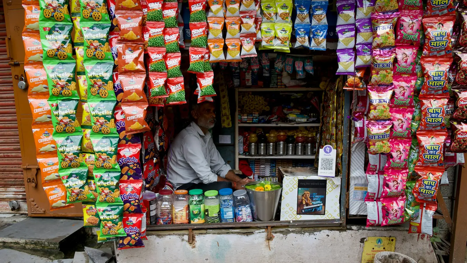 A small roadside shop crowded with snacks and drinks