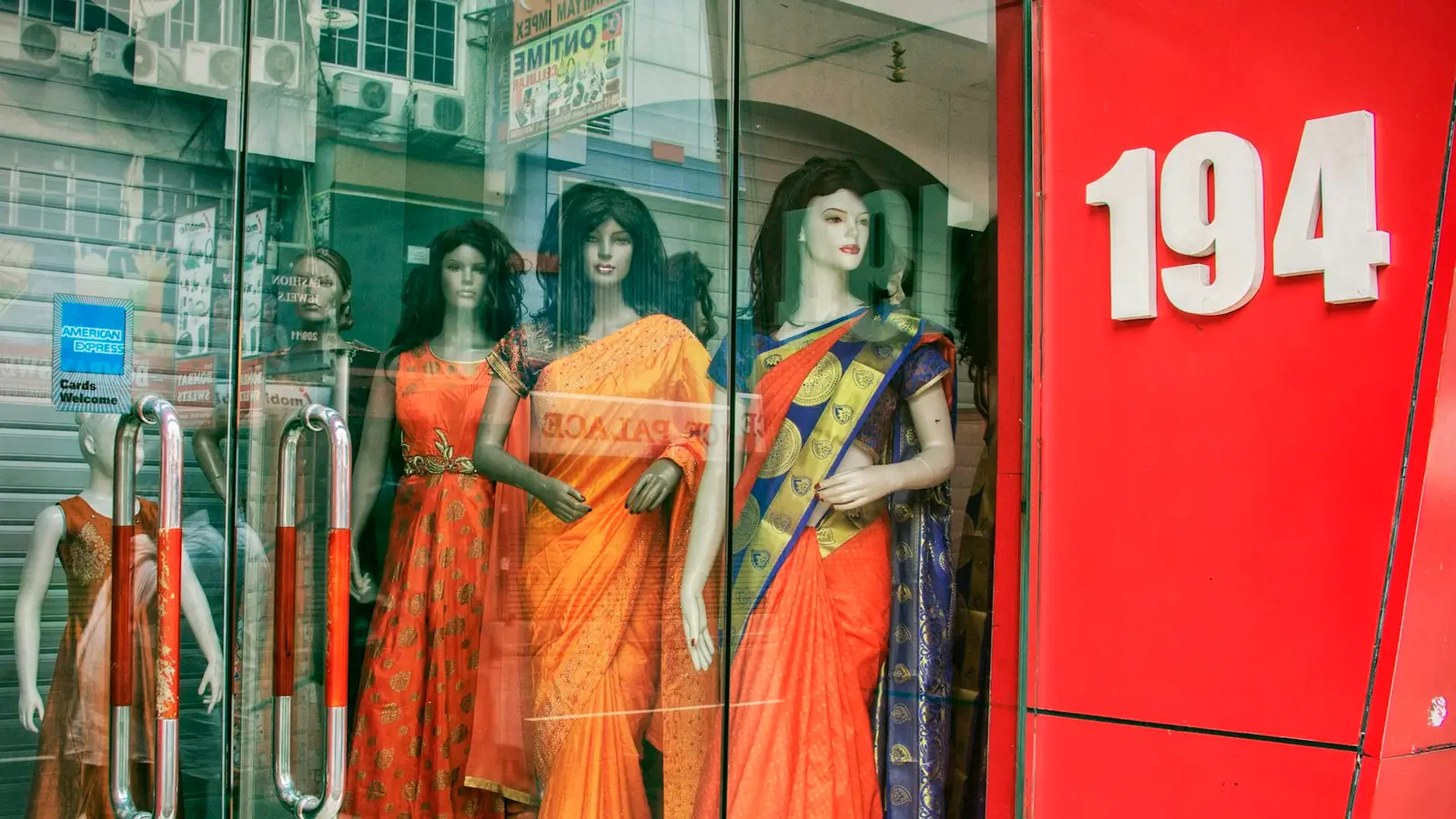 Dukan ki khidki me rangeen sariyon me mannequin