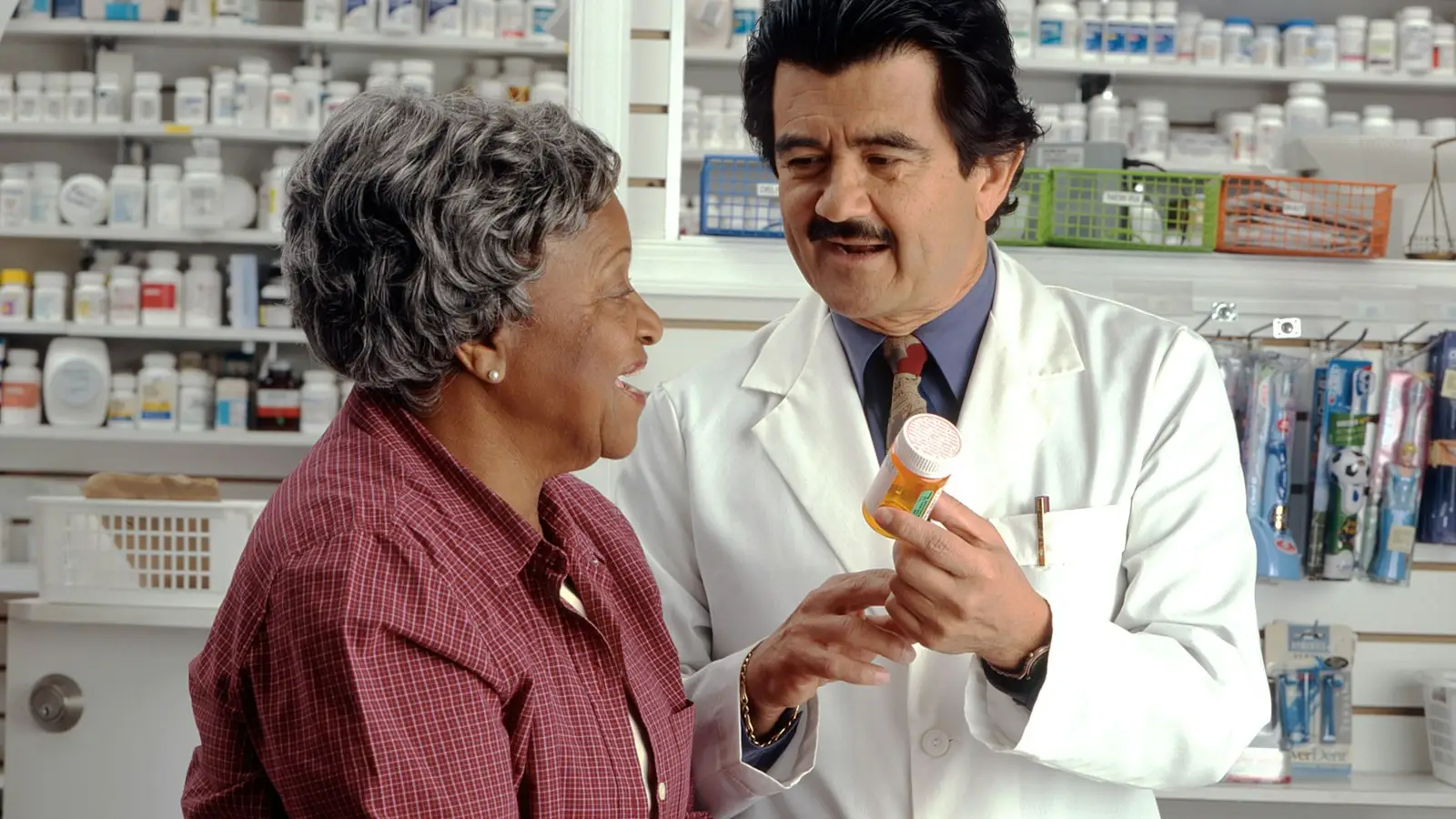 A pharmacist explaining a medicine bottle to an older woman