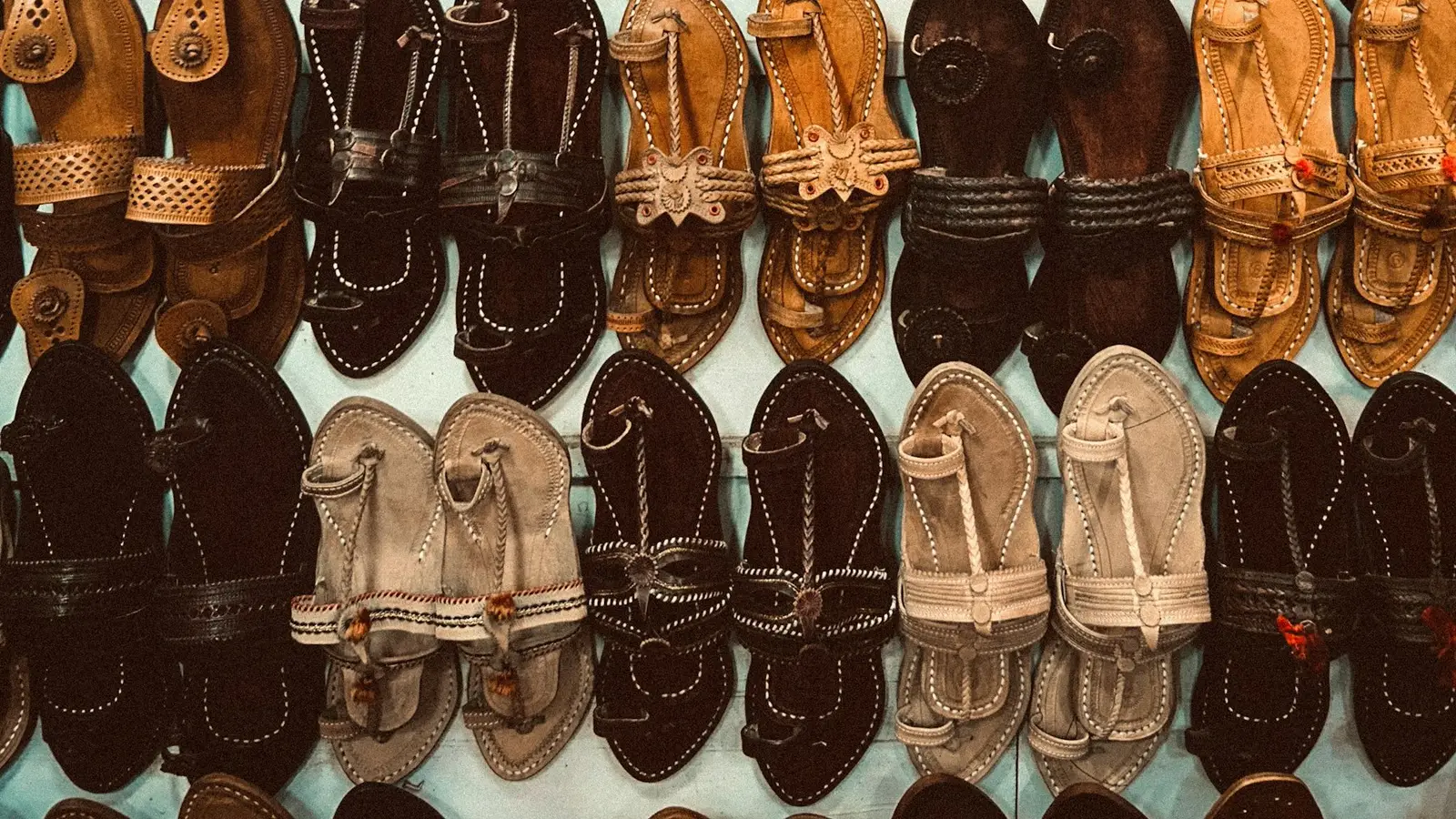 Footwear dukan ki deewar par tangi chamde ki chappal aur sandal