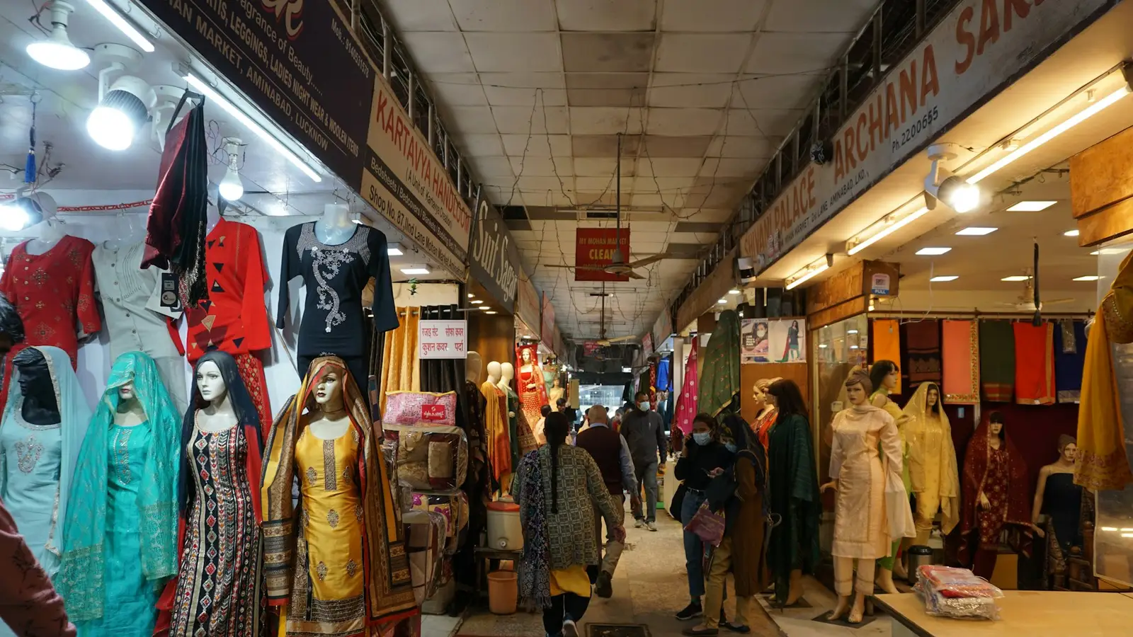 A clothing market lane with dresses and kurtas on display